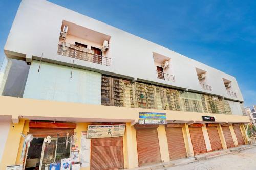 a white building with two balconies on a street at Hotel O The smart haven in Ghaziabad
