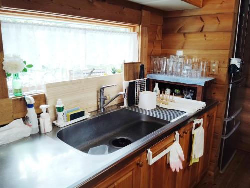 a kitchen with a sink and a counter top at Siodomi Marinki shared wood lodge, pets allowed for a fee in Ōkuki