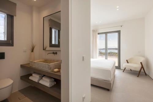 a bathroom with a sink and a toilet and a bed at Celestial Villas in Santa Maria