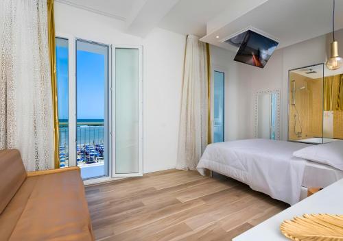 a bedroom with a bed and a large window at Miami Suite in Bellaria-Igea Marina