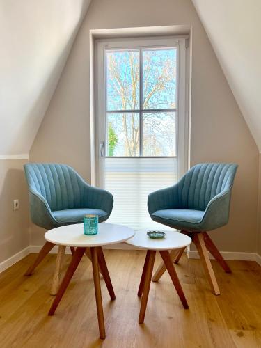 two chairs and a table in a room with a window at Ferienhaus Sundevit - exklusives Ferienhaus mit Infrarotsauna, Whirlpool-Wanne und Kamin in Putgarten
