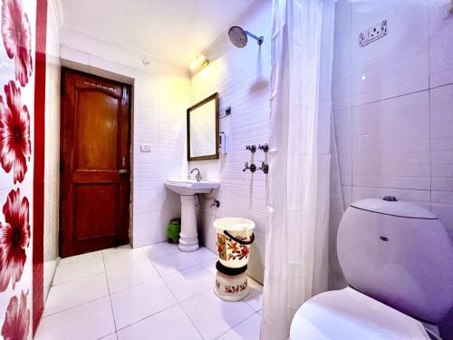 a white bathroom with a toilet and a sink at Hotel Ambience Hill Nainital - near Bhowali in Nainital