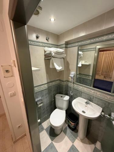 a bathroom with a toilet and a sink at Hostal Arévacos in Soria