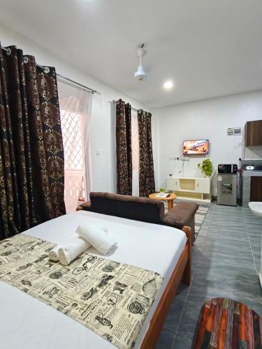 a bedroom with a bed and a living room at Stylish Mtwapa Studio with Rooftop Pool View in Mtwapa