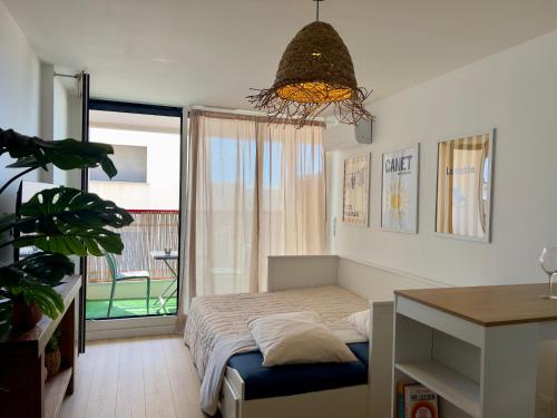 a small bedroom with a bed and a balcony at Résidence de Noëlle in Canet-en-Roussillon