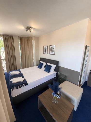 a hotel room with a large bed and a table at Opera Family Hotel - former City Mark hotel in Varna City