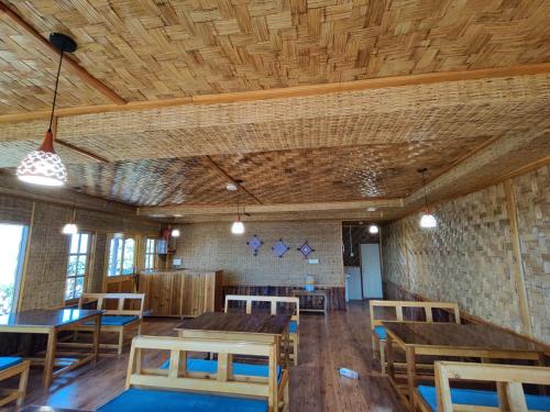 a dining room with wooden tables and chairs at Taray Heem Homestay in Ravangla