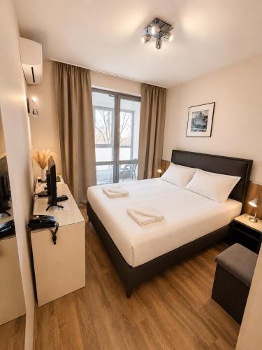 a bedroom with a bed and a desk with a computer at Opera Family Hotel - former City Mark hotel in Varna City