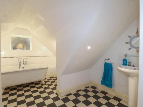 a bathroom with a white tub and a sink at The Old School House in Chichester