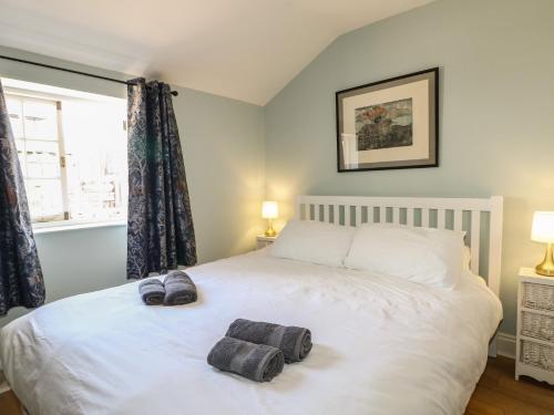 a bedroom with a white bed with two towels on it at The Old School House in Chichester