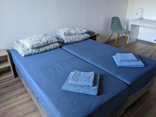 a bedroom with a blue bed with towels on it at Na Batorym in Chorzów