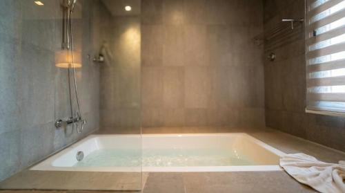 a bath tub in a bathroom with a shower at Villa AG Marrakech in Marrakesh