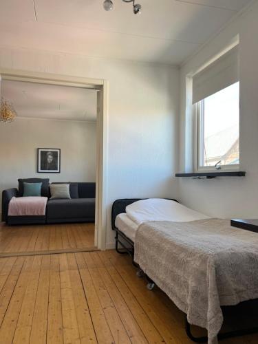 a bedroom with two beds and a couch at One room apartment the Square in Ystad