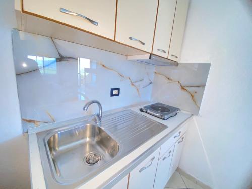 a small kitchen with a sink and a stove at APARTAMENT RADHIME in Vlorë