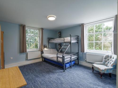 a bedroom with a bunk bed and a chair at YHA Stratford-Upon-Avon in Stratford-upon-Avon