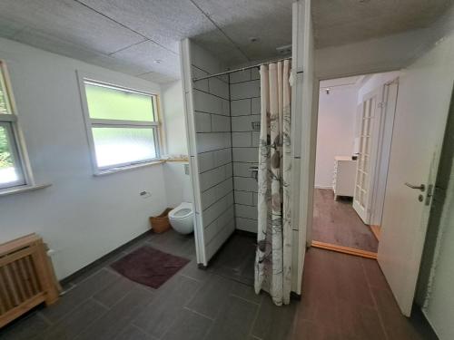 an empty bathroom with a toilet and a window at Byhus i Glyngøre in Glyngøre