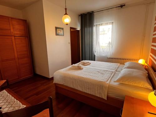 a bedroom with a bed and a window at Apartments Prendivoj in Malinska
