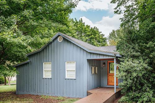 a blue shed with a porch and a door at Bluebird Cottage in Roseland