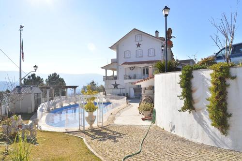 a house with a swimming pool in front of a house at Casa Estrela de Alva in Seia
