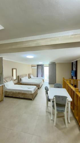 a hotel room with two beds and a table and chairs at Hotel Apart Resilient in Golem