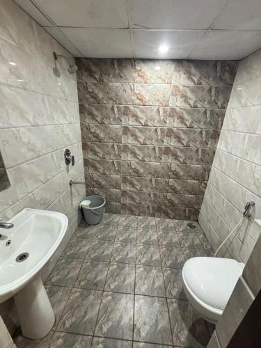 a bathroom with a sink and a toilet at De Classico Hotel - HBR Layout in Bangalore
