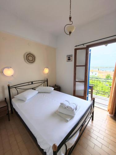 ein Schlafzimmer mit einem großen weißen Bett und einem Balkon in der Unterkunft Villa Orizontes in Spetses