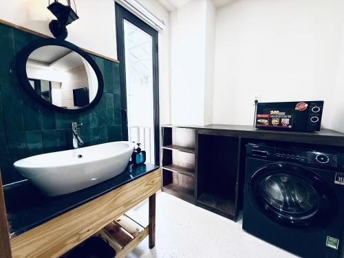 a bathroom with a sink and a washing machine at Mint Home in Danang