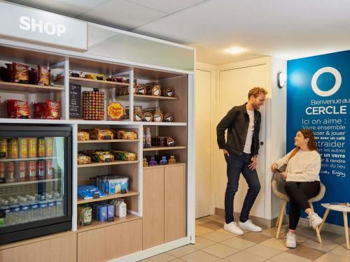 a man and a woman standing in a store aisle at Aparthotel Adagio Access Nice Magnan in Nice
