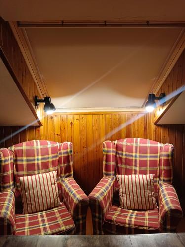 two chairs sitting in a room with wooden walls at Snow paradise in Naut Aran