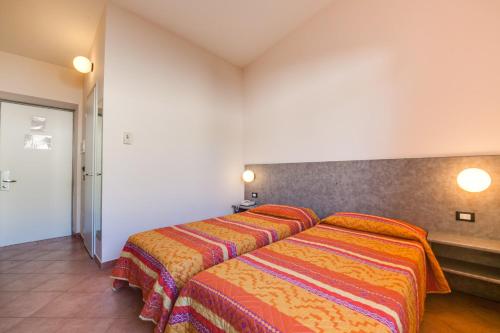 a bedroom with two beds with colorful blankets at Autohotel Venezia in Mirano