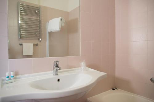 a bathroom with a sink and a mirror and a toilet at Autohotel Venezia in Mirano