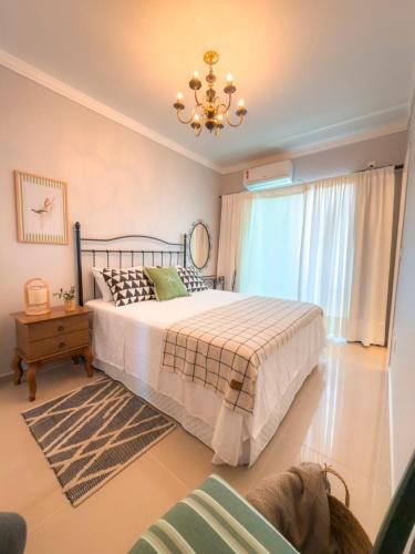 a bedroom with a bed and a chandelier at Solar Primavera in Palhoça