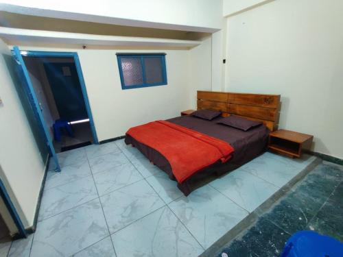 a bedroom with a bed with a red blanket at Leela's Abode in Bhowāli