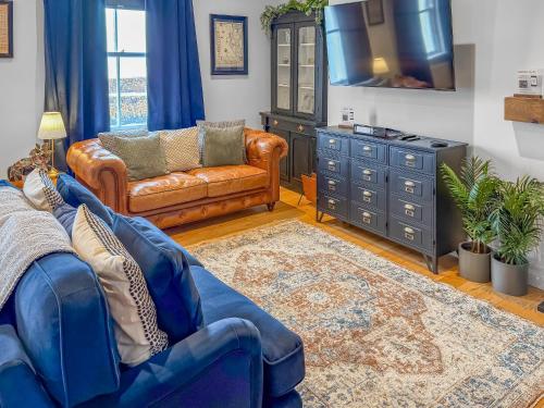 a living room with a couch and a tv at Nautilus Cottage in Cellardyke