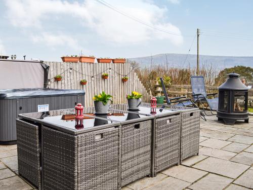 a patio with a table with potted plants on it at Peacock Cottage - Uk36422 in Talybont