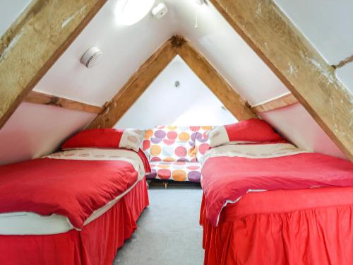 two beds in a attic room with a couch at Peacock Cottage - Uk36422 in Talybont