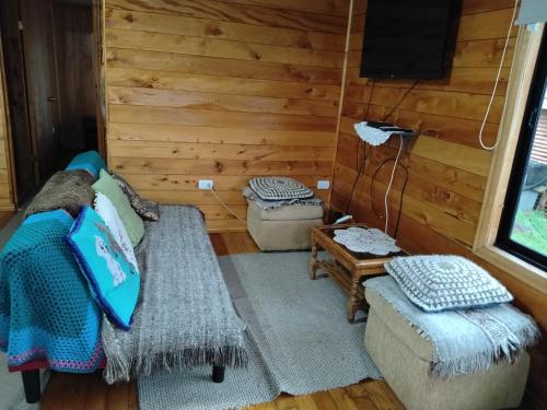 a living room with a couch and a tv at Cabañas miranda in Quellón