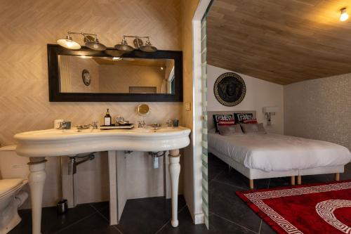 a bathroom with a sink and a bed in a room at Palazzo Di Acqua in Le Mans