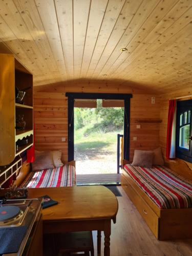 a room with a bed and a table in a cabin at Hébergements Insolites Camping la Pinède des Mées in Les Mées