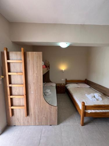 a bedroom with two bunk beds and a ladder at Kalouda Rooms in Paralía Skotínis