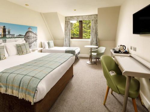 a hotel room with a bed and a desk at Mercure Hull Grange Park Hotel in Hull