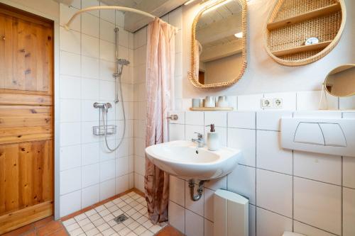 a bathroom with a sink and a shower and mirror at Atempause in Fehmarn