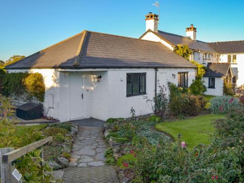 a white house with a garden in front of it at Bournestream Cottage in Withycombe