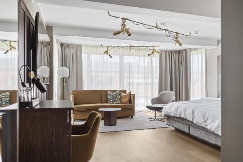 a bedroom with a bed and a living room at Best Western Plus Savoy Lulea in Luleå