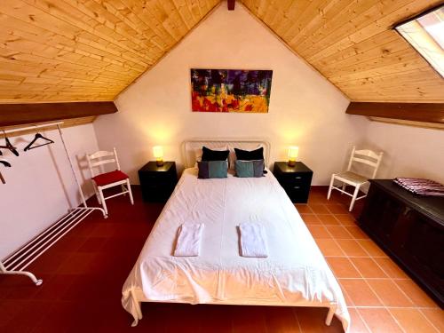 a bedroom with a white bed in a attic at BuganVilla in Santiago do Cacém