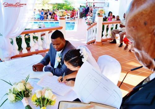a bride and groom signing their vows at their wedding at Hotel Alexandrina in Kingstown
