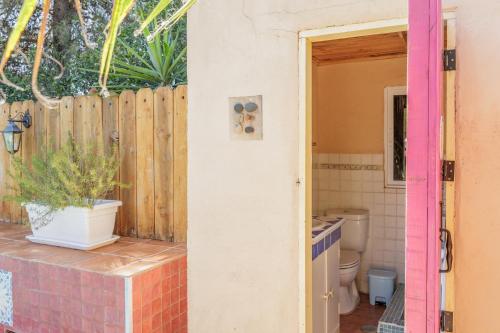 a bathroom with a toilet and a wooden fence at El Grifo Casa De Campo Con Piscina in Carmona