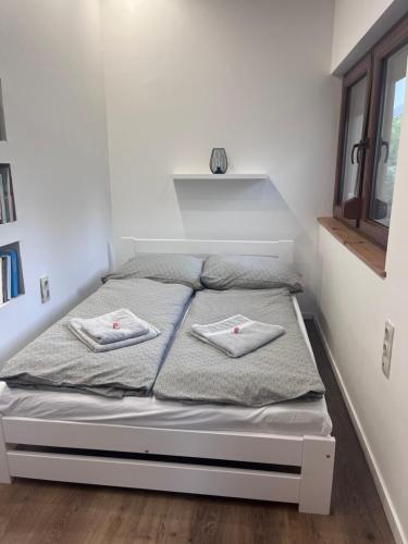 a bedroom with a bed with two towels on it at Vadkörte Balaton Apartman in Balatonfůzfő