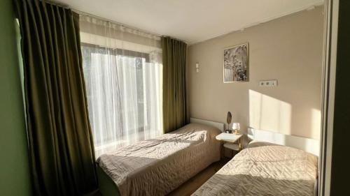a hotel room with two beds and a window at Asia-palace in Chon-Sary-Oy