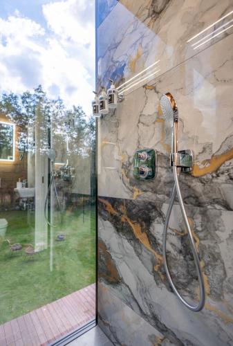 a shower in a bathroom with a glass door at Forest Reflection Minivilla in Partsi